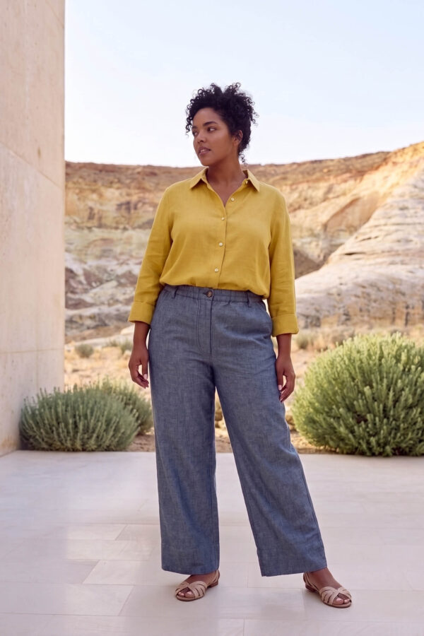 Mujer vistiendo blusa con botones de lino amarilla y pantalon estilo jeans de lino y algodón