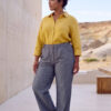 Mujer vistiendo blusa con botones de lino amarilla y pantalon estilo jeans de lino y algodón