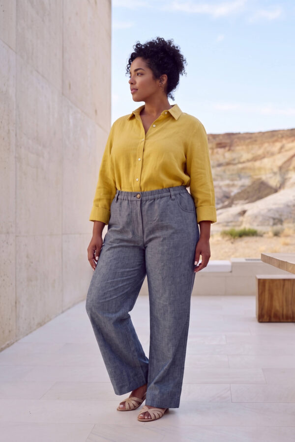 Mujer vistiendo blusa con botones de lino amarilla y pantalon estilo jeans de lino y algodón