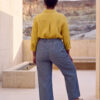Mujer vistiendo blusa con botones de lino amarilla y pantalon estilo jeans de lino y algodón