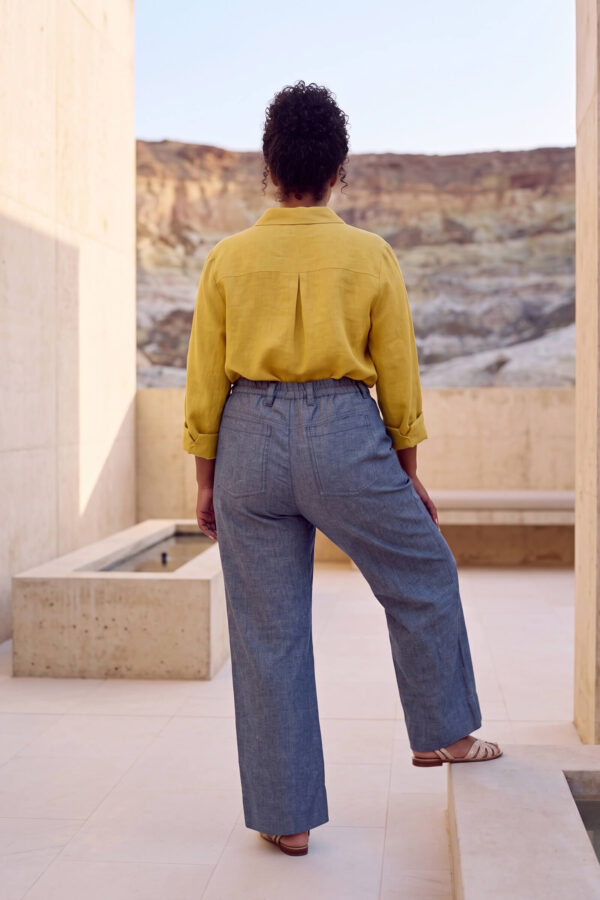 Mujer vistiendo blusa con botones de lino amarilla y pantalon estilo jeans de lino y algodón