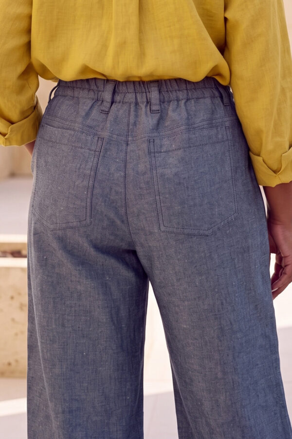 Mujer vistiendo blusa con botones de lino amarilla y pantalon estilo jeans de lino y algodón