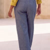 Mujer vistiendo blusa con botones de lino amarilla y pantalon estilo jeans de lino y algodón