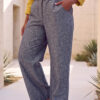 Mujer vistiendo blusa con botones de lino amarilla y pantalon estilo jeans de lino y algodón