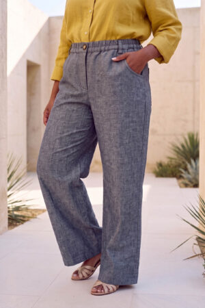 Mujer vistiendo blusa con botones de lino amarilla y pantalon estilo jeans de lino y algodón