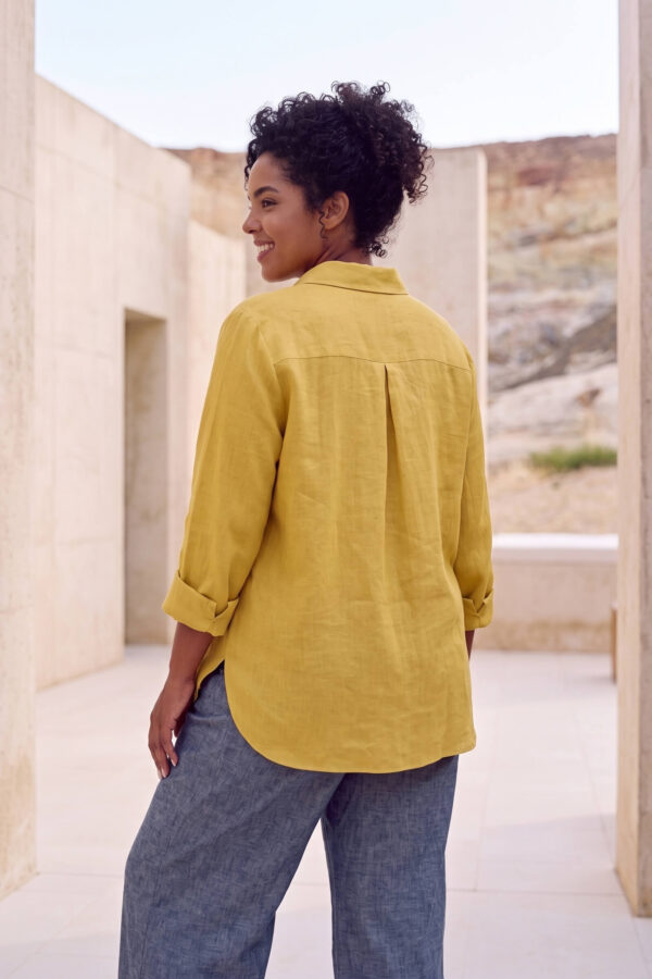 Mujer vistiendo blusa con botones de lino amarilla y pantalon estilo jeans de lino y algodón