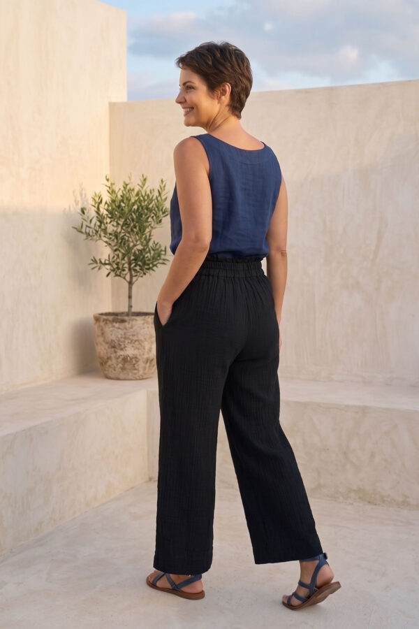 Mujer vistiendo blusa de lino azul marino y pantalon ancho de lino negro