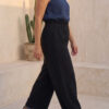 Mujer vistiendo blusa de lino azul marino y pantalon ancho de lino negro
