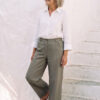 Mujer vistiendo blusa con botones de lino blanca y pantalon estilo jeans de lino y algodón verde seco