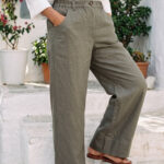Mujer vistiendo blusa con botones de lino blanca y pantalon estilo jeans de lino y algodón verde seco