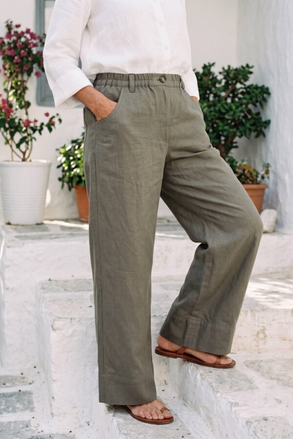 Mujer vistiendo blusa con botones de lino blanca y pantalon estilo jeans de lino y algodón verde seco