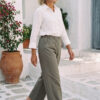 Mujer vistiendo blusa con botones de lino blanca y pantalon estilo jeans de lino y algodón verde seco