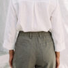Mujer vistiendo blusa con botones de lino blanca y pantalon estilo jeans de lino y algodón verde seco