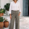 Mujer vistiendo blusa con botones de lino blanca y pantalon estilo jeans de lino y algodón verde seco