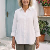 Mujer vistiendo blusa con botones de lino blanca y pantalon estilo jeans de lino y algodón verde seco