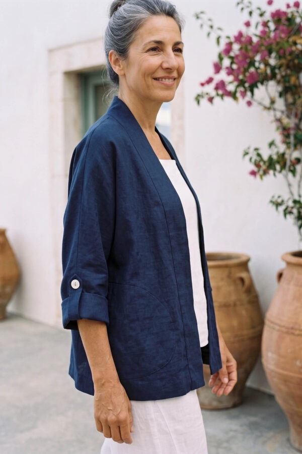 Mujer vistiendo blusa y pantalon de lino blanco y saco azul marino de fibras naturales