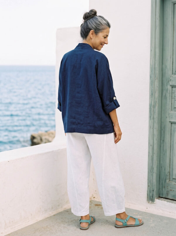 Mujer vistiendo blusa y pantalon de lino blanco y saco azul marino de fibras naturales