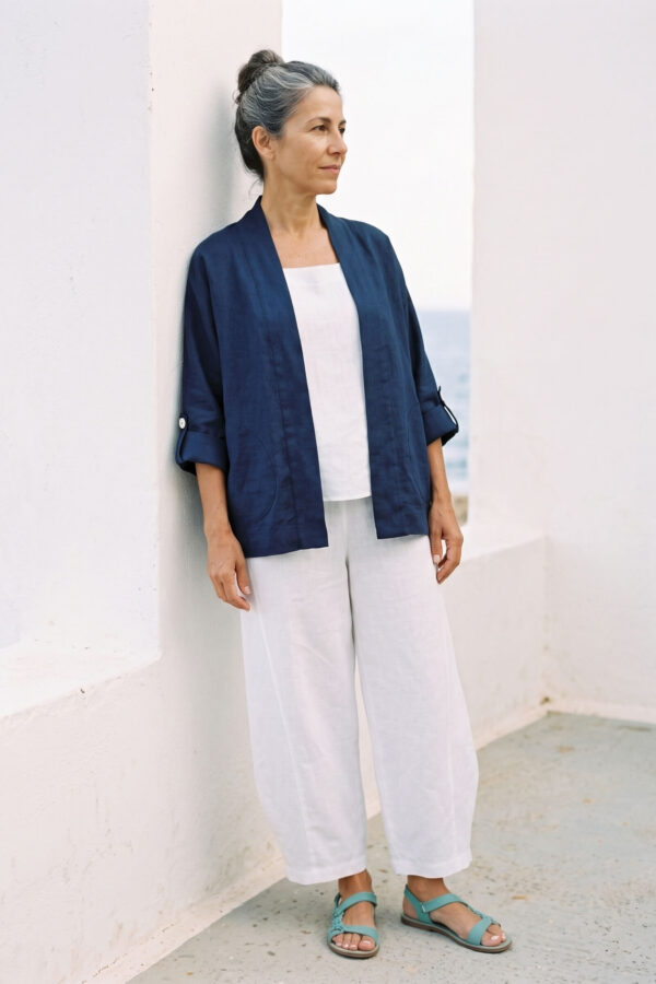 Mujer vistiendo blusa y pantalon de lino blanco y saco azul marino de fibras naturales