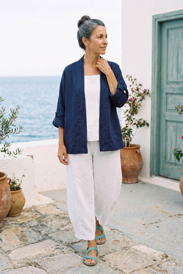 Mujer vistiendo blusa y pantalon de lino blanco y saco azul marino de fibras naturales