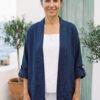 Mujer vistiendo blusa y pantalon de lino blanco y saco azul marino de fibras naturales