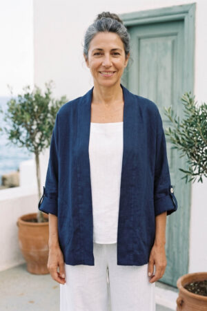 Mujer vistiendo blusa y pantalon de lino blanco y saco azul marino de fibras naturales