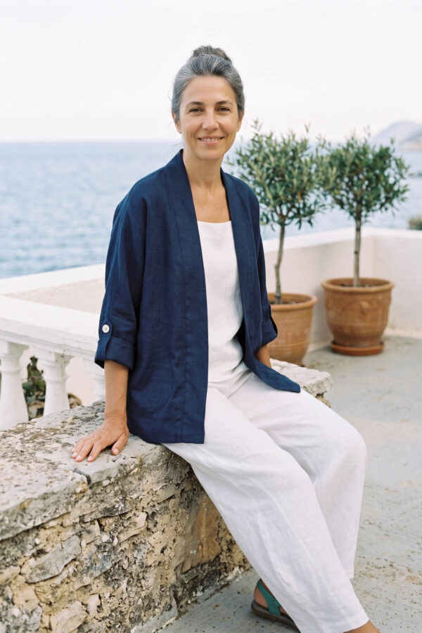 Mujer vistiendo blusa y pantalon de lino blanco y saco azul marino de fibras naturales