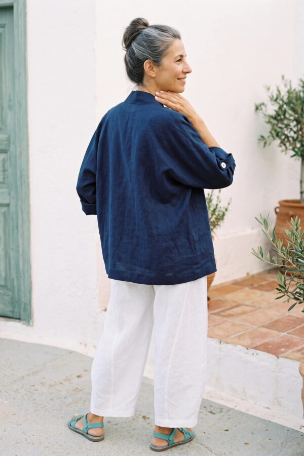 Mujer vistiendo blusa y pantalon de lino blanco y saco azul marino de fibras naturales