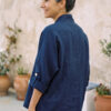 Mujer vistiendo blusa y pantalon de lino blanco y saco azul marino de fibras naturales