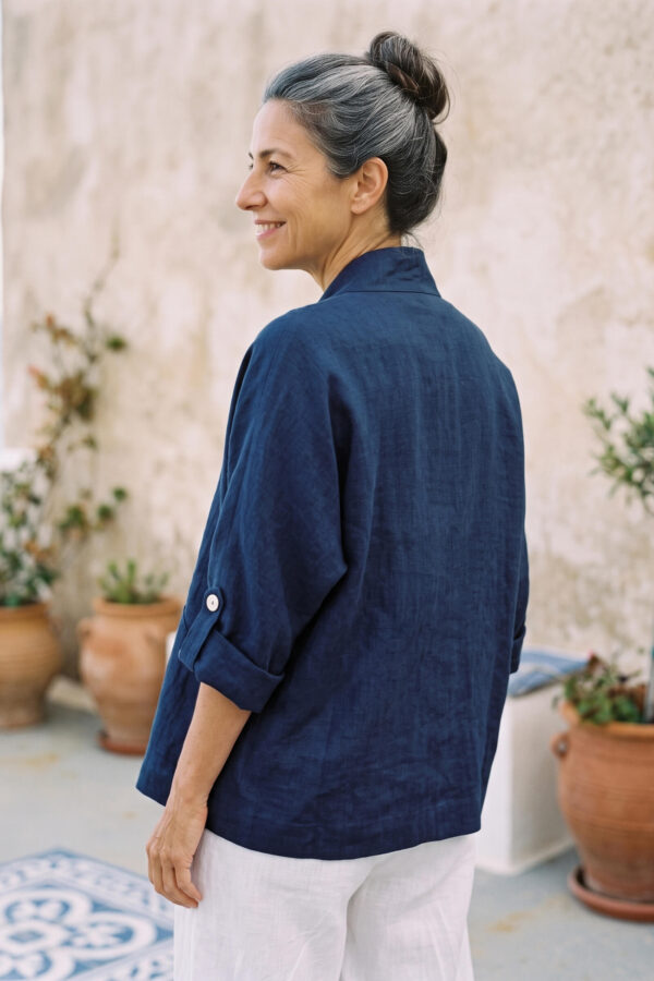 Mujer vistiendo blusa y pantalon de lino blanco y saco azul marino de fibras naturales