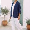 Mujer vistiendo blusa y pantalon de lino blanco y saco azul marino de fibras naturales