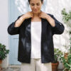 Mujer vistiendo blusa blanca, pantalon avena y saco de lino negro