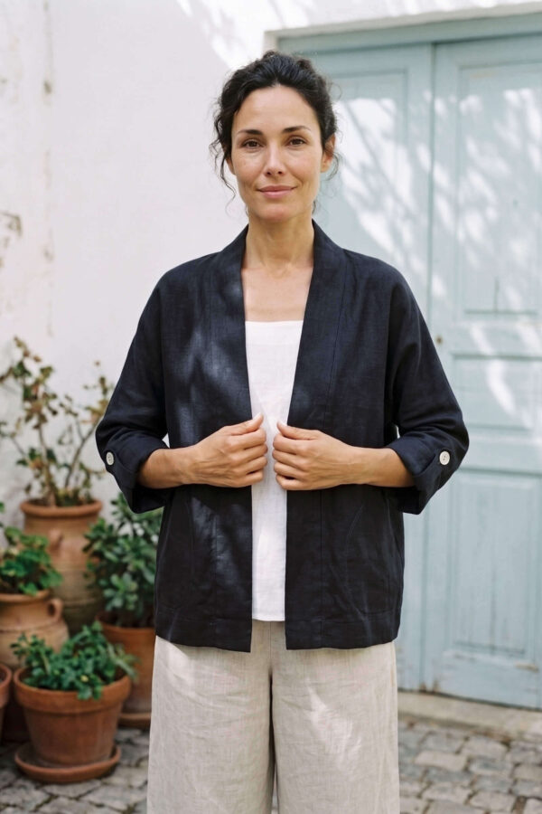 Mujer vistiendo blusa blanca, pantalon avena y saco de lino negro
