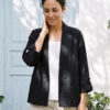 Mujer vistiendo blusa blanca, pantalon avena y saco de lino negro
