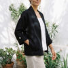 Mujer vistiendo blusa blanca, pantalon avena y saco de lino negro
