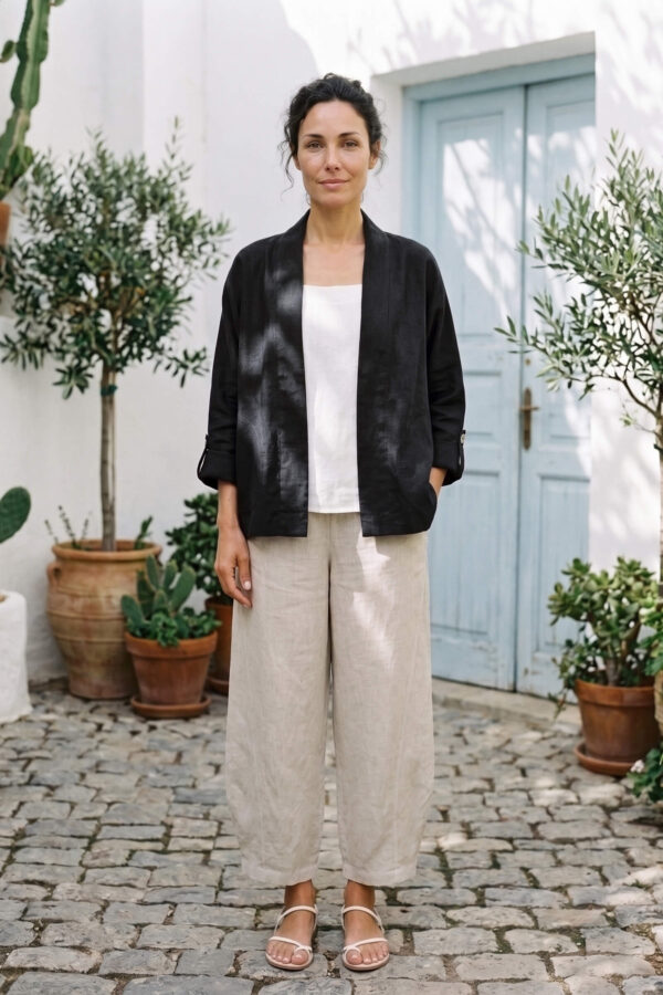 Mujer vistiendo blusa blanca, pantalon avena y saco de lino negro