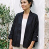 Mujer vistiendo blusa blanca, pantalon avena y saco de lino negro