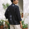 Mujer vistiendo blusa blanca, pantalon avena y saco de lino negro