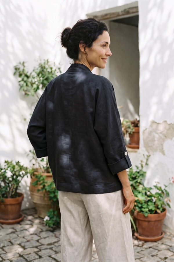 Mujer vistiendo blusa blanca, pantalon avena y saco de lino negro