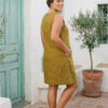 Mujer vistiendo vestido corto con bolsas en lino natural color verde hoja