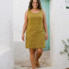 Mujer vistiendo vestido corto con bolsas en lino natural color verde hoja