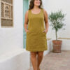 Mujer vistiendo vestido corto con bolsas en lino natural color verde hoja