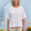 Mujer vistiendo blusa manga amplia de lino blanca y pantalon color avena