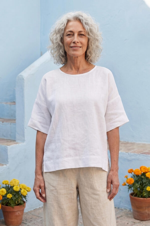 Mujer vistiendo blusa manga amplia de lino blanca y pantalon color avena