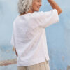 Mujer vistiendo blusa manga amplia de lino blanca y pantalon color avena
