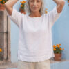 Mujer vistiendo blusa manga amplia de lino blanca y pantalon color avena