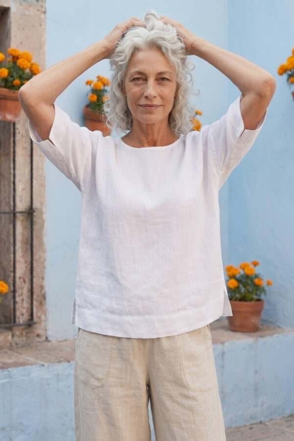 Mujer vistiendo blusa manga amplia de lino blanca y pantalon color avena