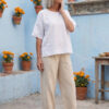 Mujer vistiendo blusa manga amplia de lino blanca y pantalon color avena