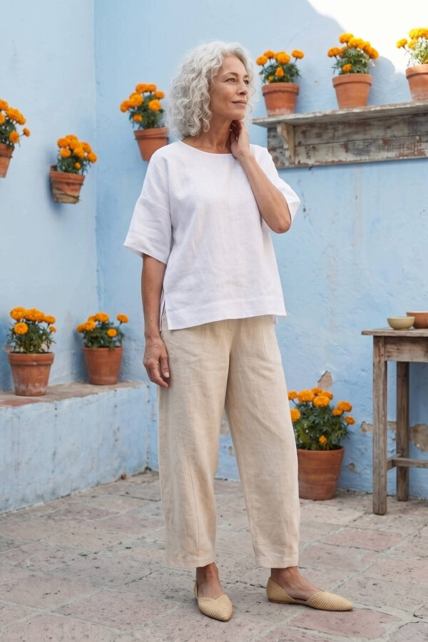 Mujer vistiendo blusa manga amplia de lino blanca y pantalon color avena