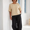 Mujer vistiendo blusa manga amplia de lino color paja y pantalon negro
