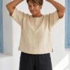Mujer vistiendo blusa manga amplia de lino color paja y pantalon negro